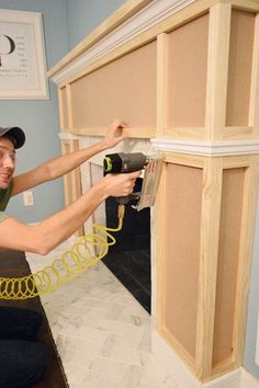 a man is working on the cabinets in his home with a power drill and screwdriver