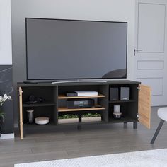 a flat screen tv sitting on top of a wooden entertainment center