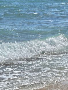 a man riding a surfboard on top of a wave in the ocean next to shore