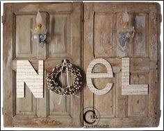 an old door with the word noel written on it and a wreath in front of it