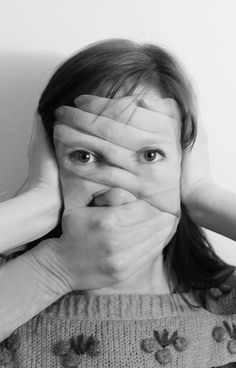 a woman covering her eyes with both hands