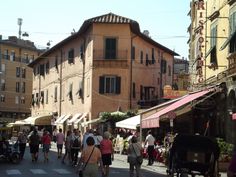 many people are walking down the street near buildings