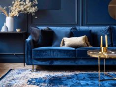 a living room with blue couches and rugs on the floor next to a table