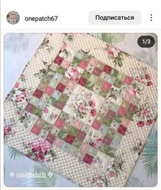 a quilted table topper with pink and green flowers on it, sitting on a bed