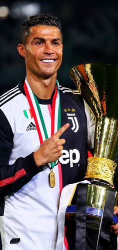 the soccer player is holding up his trophy