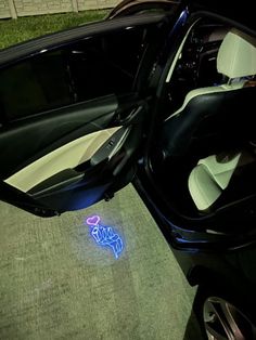 the interior of a car with its door open and lights on, in front of it