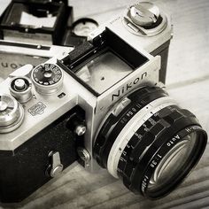 an old camera sitting on top of a wooden table