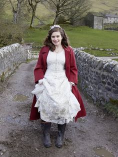 a woman in a white dress and red coat