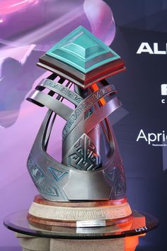 an award is displayed on top of a pedestal in front of a purple and blue background