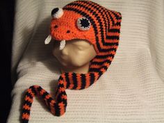 an orange and black knitted animal hat on top of a mannequin's head