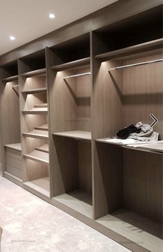 an empty walk in closet with wooden shelves