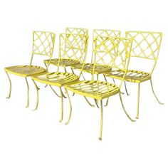 four yellow metal chairs sitting next to each other