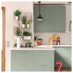 a kitchen filled with lots of green cupboards next to a sink and stove top oven