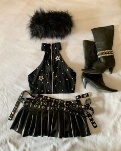 a skirt, boots and hat are laid out on a white sheet with black fur