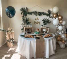 a baby shower table with balloons and cake