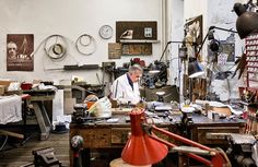 an older man working in his workshop with lots of work on the table and shelves