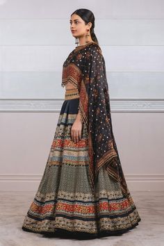 Black chanderi lehenga with geometric and floral printed motifs. Paired with printed cape attached blouse.
Component: 2
Printed
Neckline: Round
Sleeve Length: Three quarter
Fabric: Lehenga: Chanderi, Blouse: Silk
Color: Black
Tassel border
Attached cape - Aza Fashions Black Designer Wear Sets With Motifs, Black Palazzo Set For Eid Reception, Black Palazzo Set For Reception During Eid, Chanderi Sets With Motifs For Reception, Black Designer Lehenga For Transitional Season, Designer Black Lehenga For Transitional Season, Designer Black Transitional Lehenga, Transitional Designer Black Lehenga, Traditional Black Palazzo Set For Reception