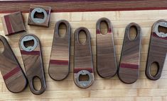 several different types of wooden knives on a table with one knife sharpener in the middle