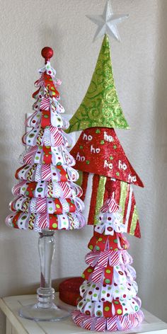 two christmas trees made out of paper sitting on top of a table