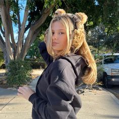 a young woman with long hair wearing a hoodie and cat ears on her head