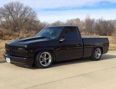 a black truck parked on the side of a road