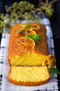 a loaf of orange pound cake on a checkered table cloth with fresh mint sprigs