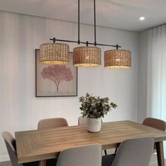 a dining room table with four chairs and a plant in the center on top of it