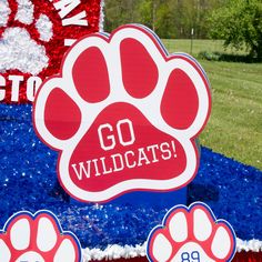 there is a red and white sign that says go wildcats with paw prints on it