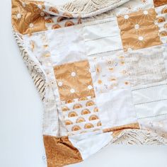 an orange and white quilt laying on top of a table