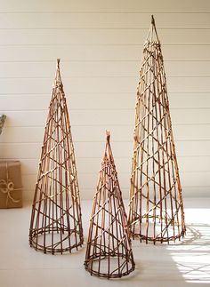 three small christmas trees made out of branches