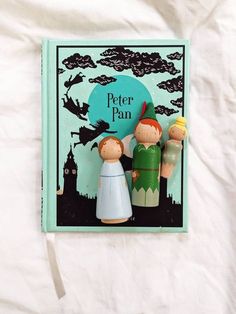 a book about peter pan and the three little pigs is laying on a white sheet