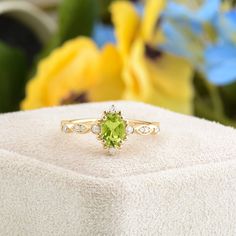 a ring sitting on top of a white box with flowers in the backgroud