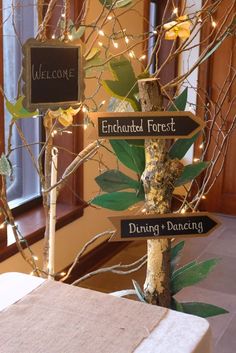 a wooden sign sitting on top of a table next to a vase filled with flowers