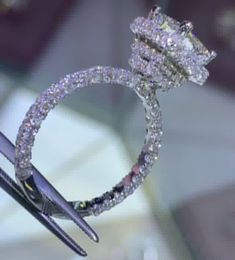 a diamond ring is being held by a pair of scissors