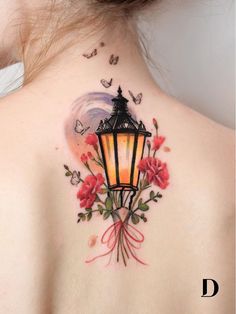 the back of a woman's neck with a lantern and flowers on it