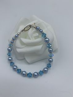 "Handcrafted light blue bracelet perfect for bridesmaids or as the bride's \"something blue\". Made from Swarovski crystals, Swarovski pearls, and .925 sterling silver.  If purchasing for a group, please send us a message and we can discuss a discount.  Sizes: 6.5\" - Petite, X-Small 7.0\" - Small 7.5\" - Medium 8.0\" - Large (For further help with sizing or custom sizing requests, send us a message. We can do children's sizes as well.)" Blue Crystal Bracelets For Anniversary, Adjustable Blue Crystal Bracelet For Anniversary, Blue Round Bead Bracelets For Weddings, Blue Round Beads Bracelet For Wedding, Adjustable Blue Crystal Bracelet For Wedding, Elegant Adjustable Light Blue Crystal Bracelet, Elegant Light Blue Adjustable Crystal Bracelet, Blue Beaded Bracelets For Weddings, Adjustable Blue Pearl Bracelet For Wedding