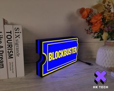 a blue and yellow block sign sitting on top of a table next to two books