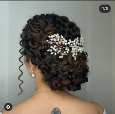 the back of a woman's head wearing a bridal hair comb with white flowers on it