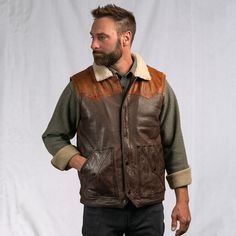 Our iconic western vest was inspired by the high mountain valleys of the Bison State. Built with a quality and craftsmanship worthy of our brand and our name. The open-arm Western Yoke exterior features 100% full grain lambskin leather, secured by a top-to-bottom antique nickel zipper with optional button-down flap and framed by twin front side pockets. Our sherpa-style polyester interior lining extends through the classic fold over collar… providing lasting comfort and mobility from the barn to Buffalo Jackson, Full Grain Leather Bag, Vintage Leather Vest, Heavy Clothing, Western Vest, Sherpa Vest, High Mountain, Side Chest, Leather Trench Coat