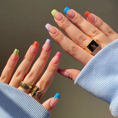 two women's hands with multicolored nails and rings