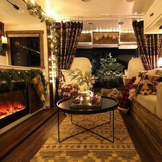 a living room filled with furniture and a fire place in front of a christmas tree