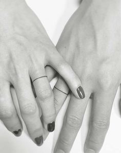 two hands holding each other with rings on their fingers