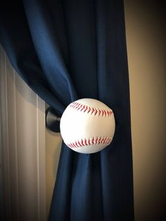 a baseball hanging on the side of a curtain