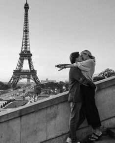 two people kissing in front of the eiffel tower