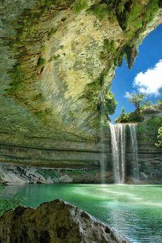 a painting of a waterfall in the middle of a river with green water and rocks