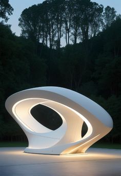 a white sculpture sitting on top of a cement floor next to trees in the background