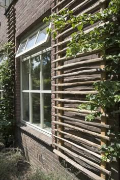 an outside view of a brick building with wood slats on the side and windows