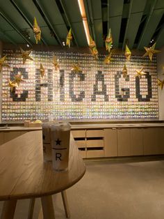 a coffee cup sitting on top of a wooden table in front of a large sign