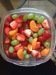 a plastic container filled with fruit on top of a table