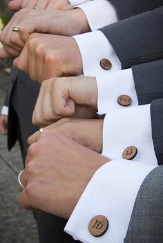 several people in suits and ties are holding their hands together with buttons on the lapels